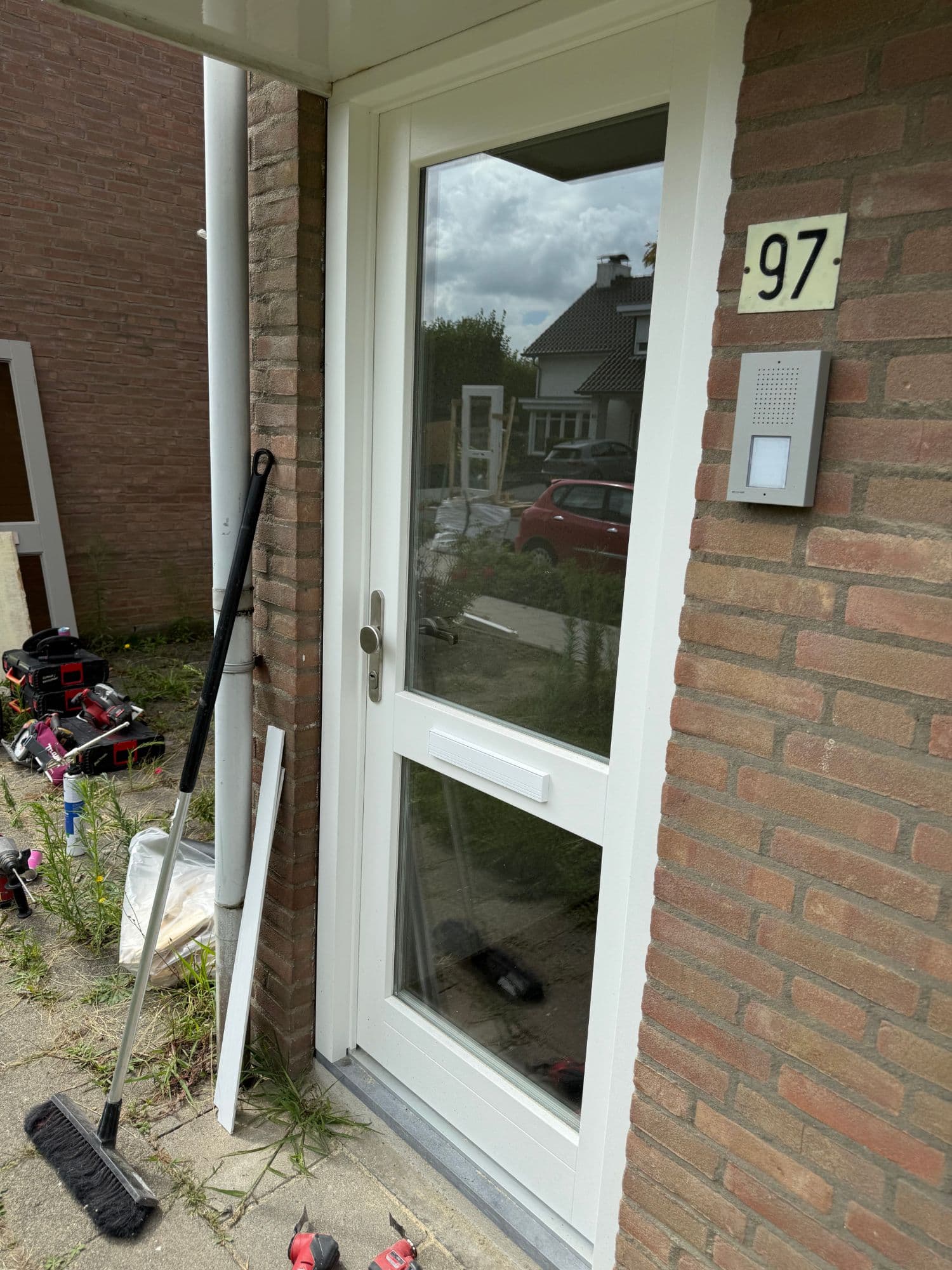 Nieuwe witte houten voordeur met glaspaneel in een bakstenen gevel, geplaatst door Sintjago in Simpelveld