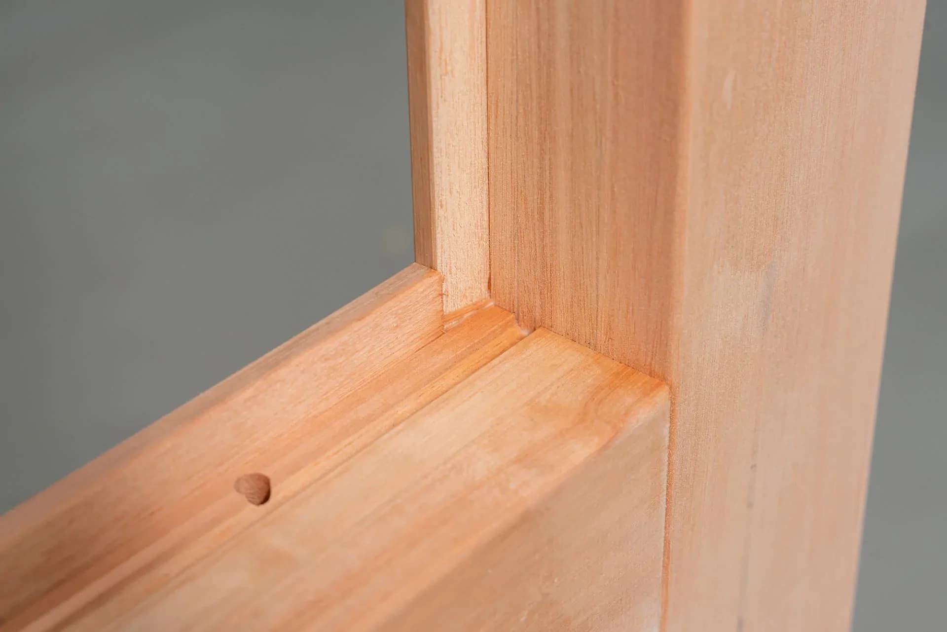 Hoekdetail van een houten kozijn met zichtbare, warme houtnerf
