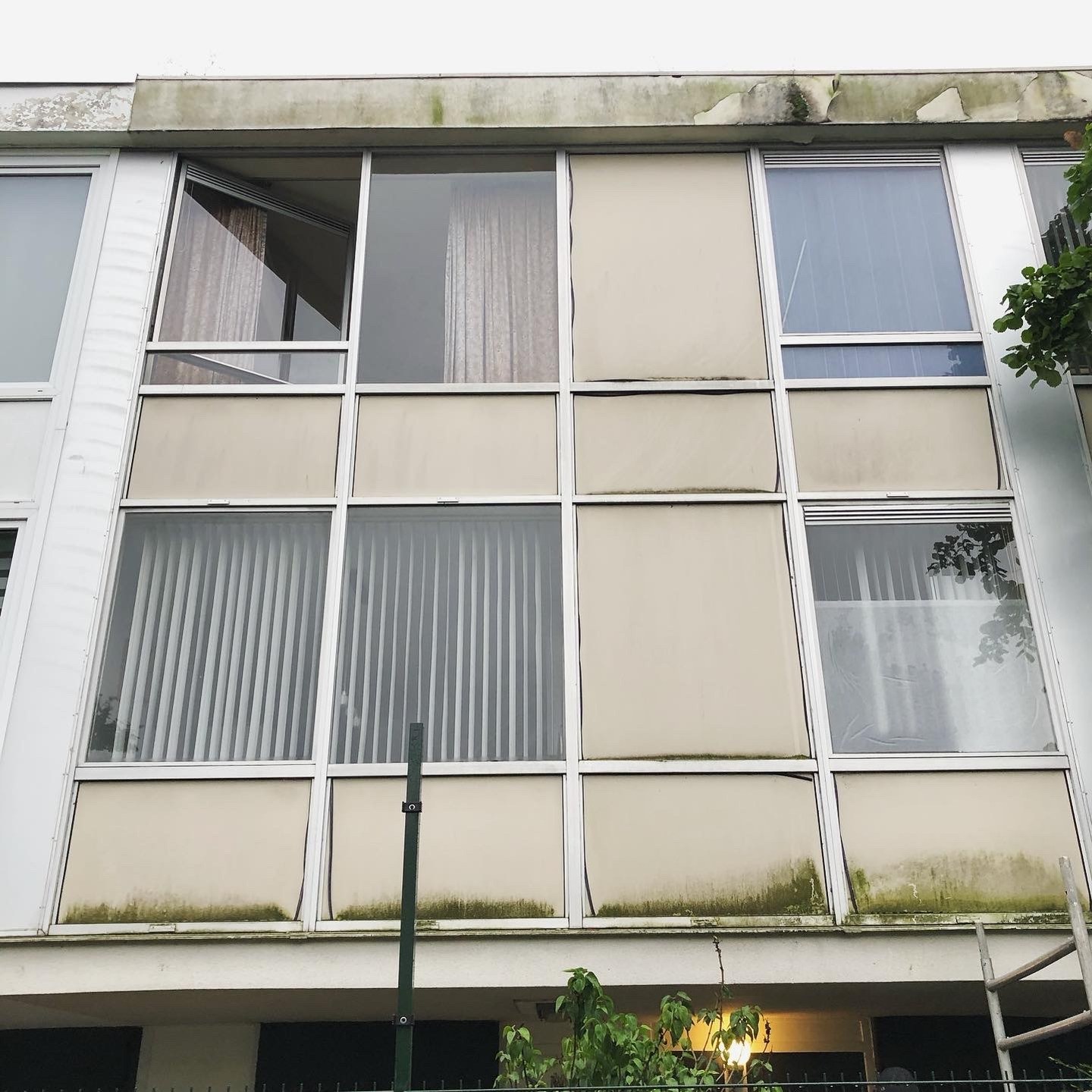 Oude, versleten vliesgevel van een drive-in woning vóór de renovatie